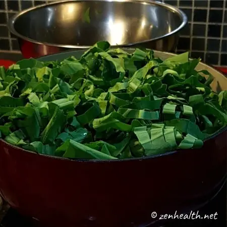 Adding chopped taro leaves and stems